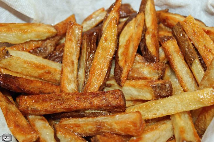 For the best oven-baked fries, parboiling them in a water and vinegar solution prior to baking them is the secret to making them as crispy as though they'd been deep fried.