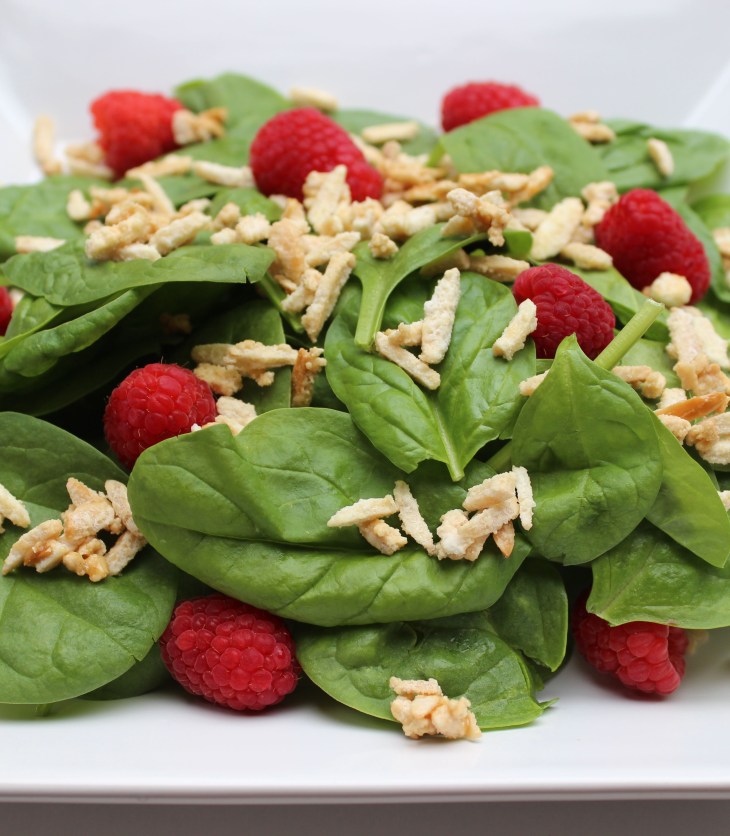 The bright, fresh tastes of spinach and raspberries are perfectly complemented by crunchy candied almonds and a tangy vinaigrette.