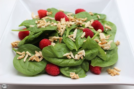 The bright, fresh tastes of spinach and raspberries are perfectly complemented by crunchy candied almonds and a tangy vinaigrette.