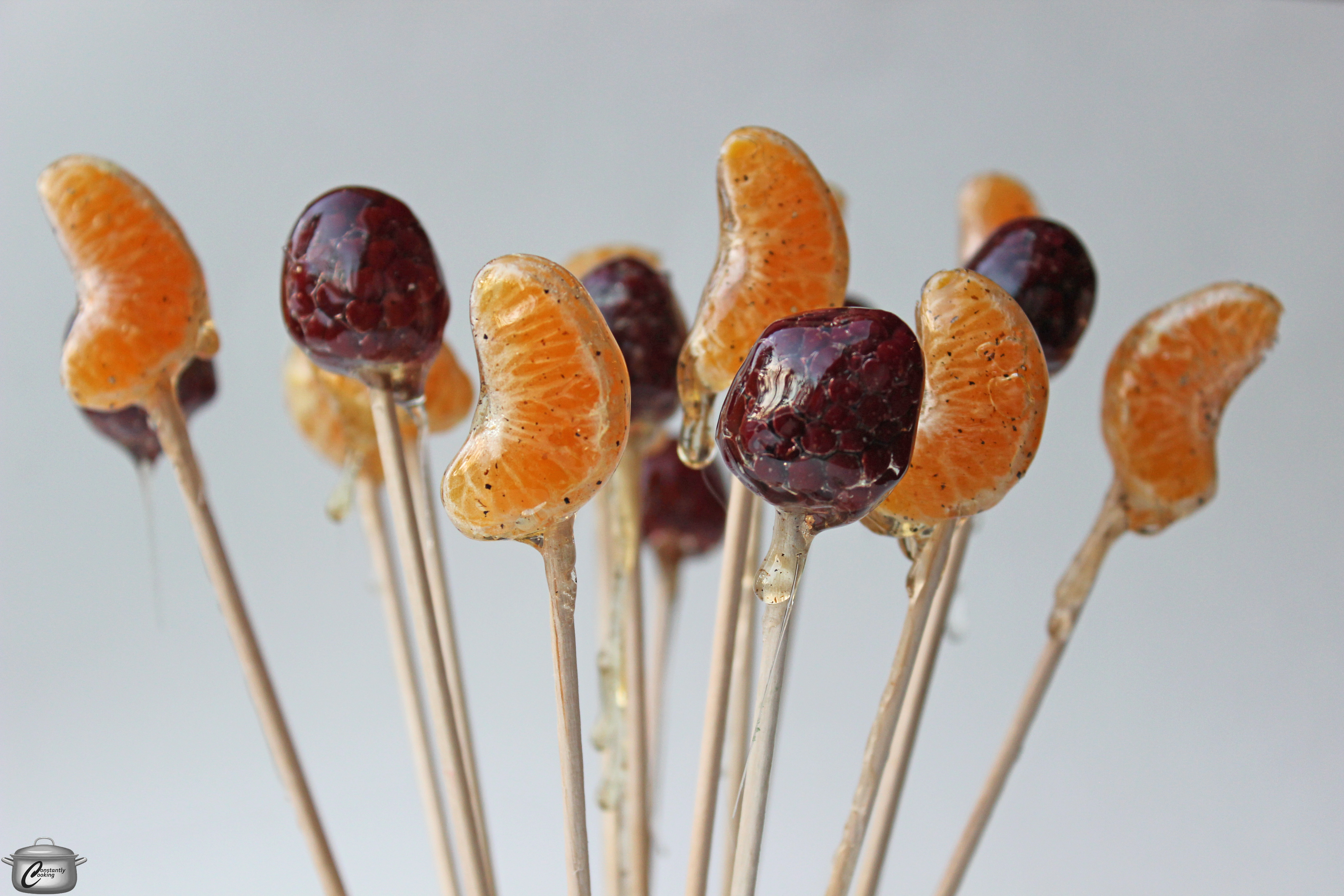 A simple hard-crack sugar syrup is the perfect way to coat pieces of fruit to turn them into lollipops!